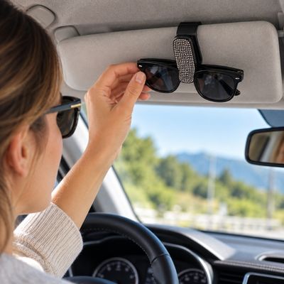 Femme range lunettes de soleil dans porte lunette voiture