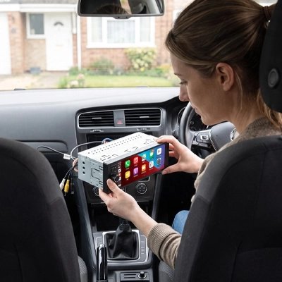 femme fixe un Autoradio carplay dans voiture