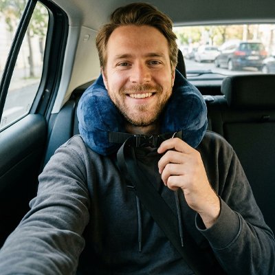 Oreiller de voyage homme voiture sourit